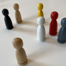 bunte Spielfiguren aus holz auf einem weißen Tisch
