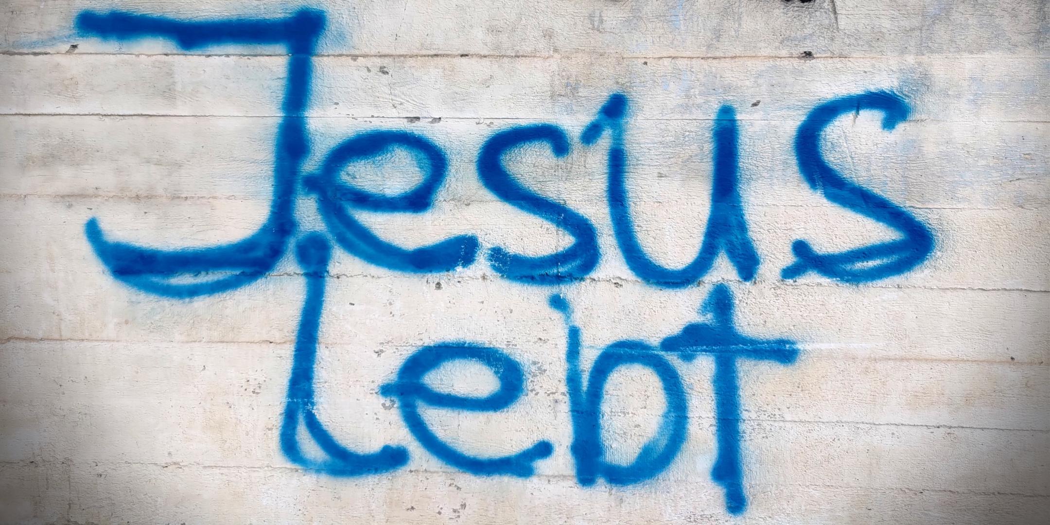 Man sieht ein Graffity an einer Mauer mit der Aufschrift 'Jesus lebt'