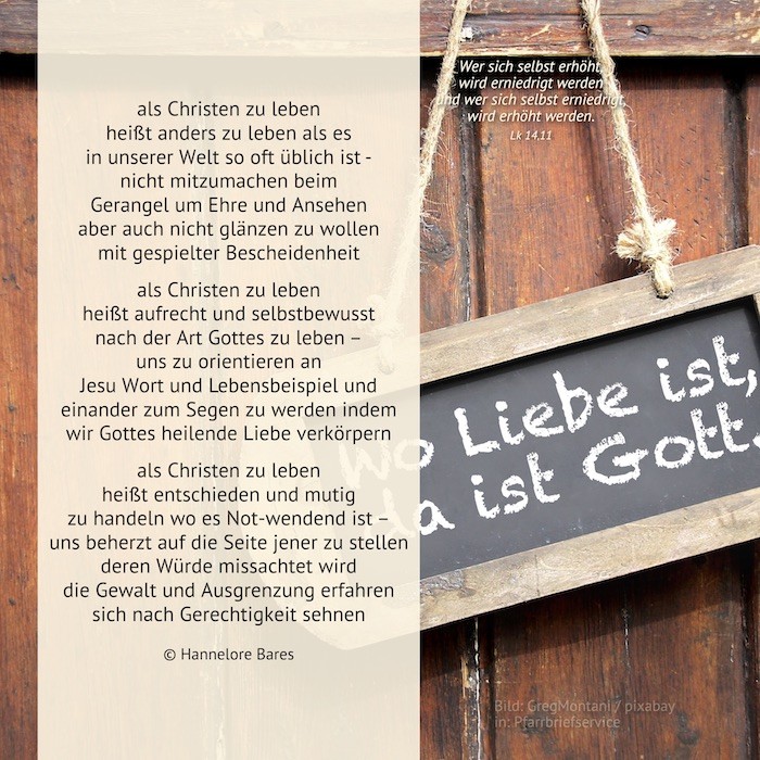 Eine Holzwand mit einer am Seil befestigten Tafel auf der 'Wo Liebe ist , da ist Gott' geschrieben steht.