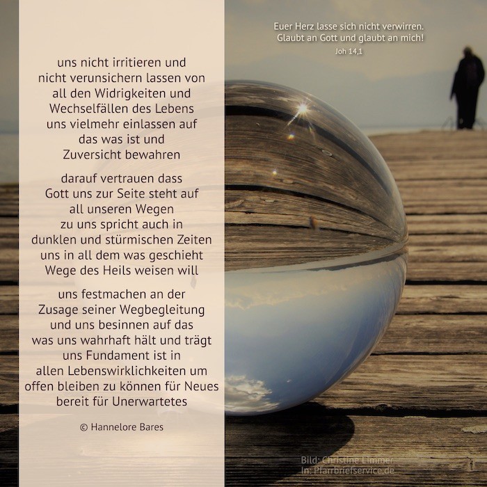 Eine Glaskugel liegt auf einem Holzsteg und spiegelt den Himmel