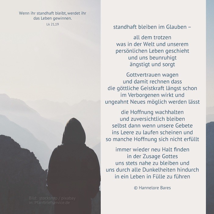 Man sieht eine Person in einem schwarzen Kapuzenpullover von hinten. Diese Person schaut auf eine Hügellandschaft im Nebel.