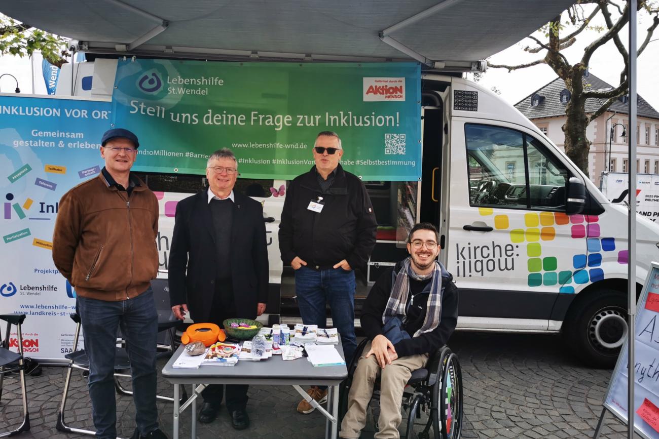 25-05-08_Aktionsstand_WND (c) Andreas Kossmann Dr. Justus Wilhelm, Dekan Klaus Leist, Christoph Morgen und Jerôme Laubenthal stehen vor dem KirchenMobil.