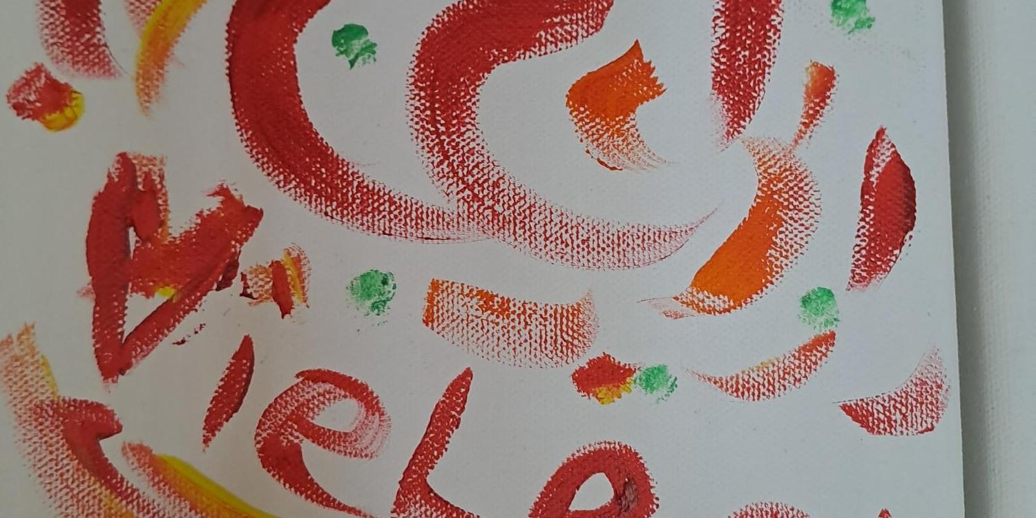 Das BIld zegt einen Ausschnitt aus einem Leinwandbild, das an den Heilig Rock Tagen 2022 zum Thema Inklusion entstanden ist. Auf dem Bild sind Pinselstriche in Rot-, Orange- und Gelbtönen zu sehen, die rund angeornet sind. Dazwischen steht das Wort Vielfalt.