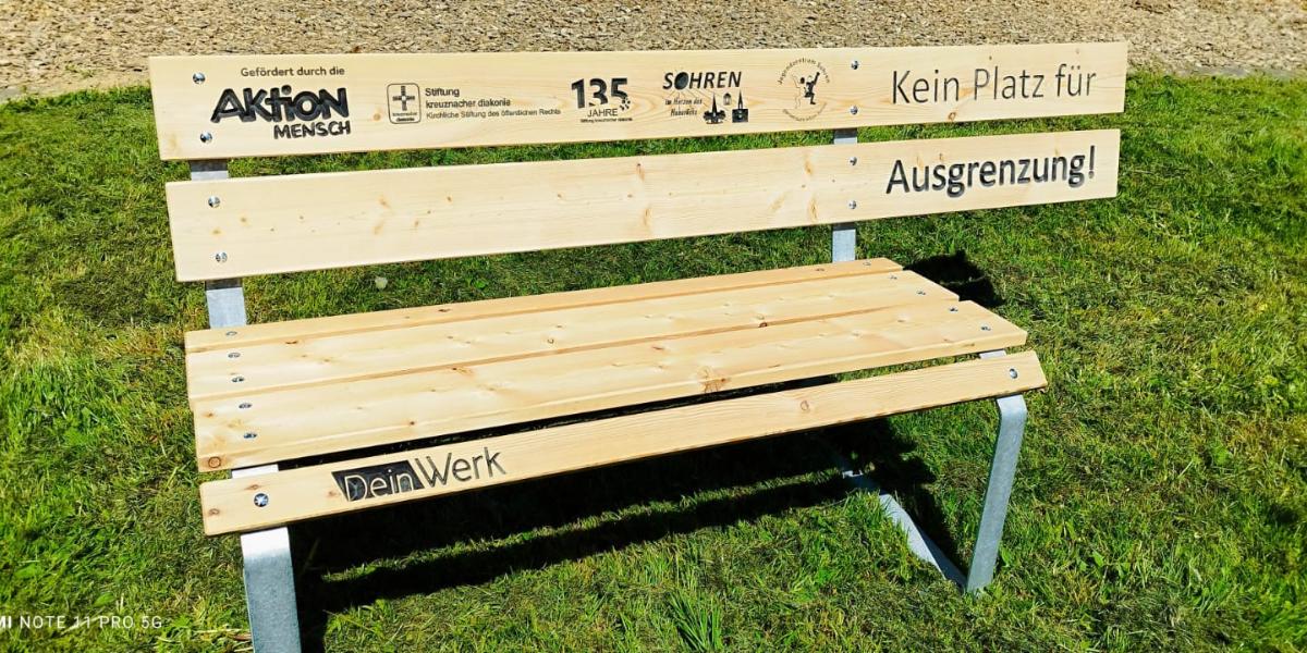 Bank gegen Ausgrenzung des Jugendzentrums Sohren. Die Bank ist an einer Seite abgeschnitten.