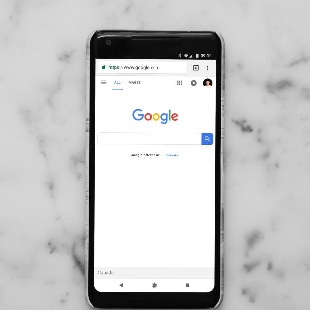 Smartphone mit geöffneter Startseite der Google-Suche