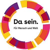 Das Bild zeigt das Logo der Arbeitsgruppe Da sein. Für Mensch und Welt. In einem Kreis steht Da sein. Für Mensch und Welt. Lila, gelbe, orange und pinke Elemente bilden den Kreis.