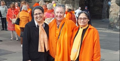 zwei Ordensschwestern mit einer Frau in der Mitte