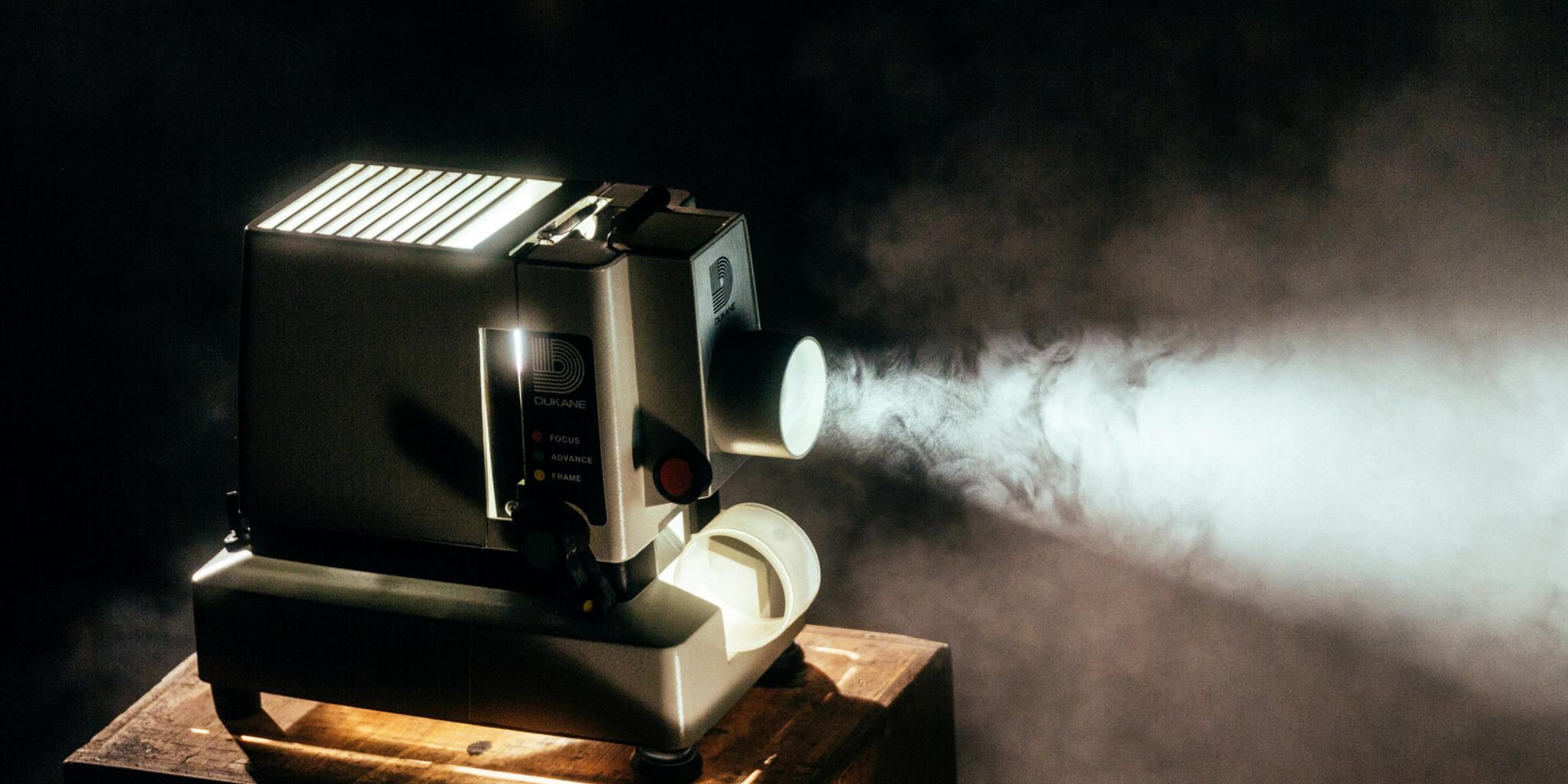 alter Kinoprojektor im Nebel stehend auf einer alten Holzkiste
