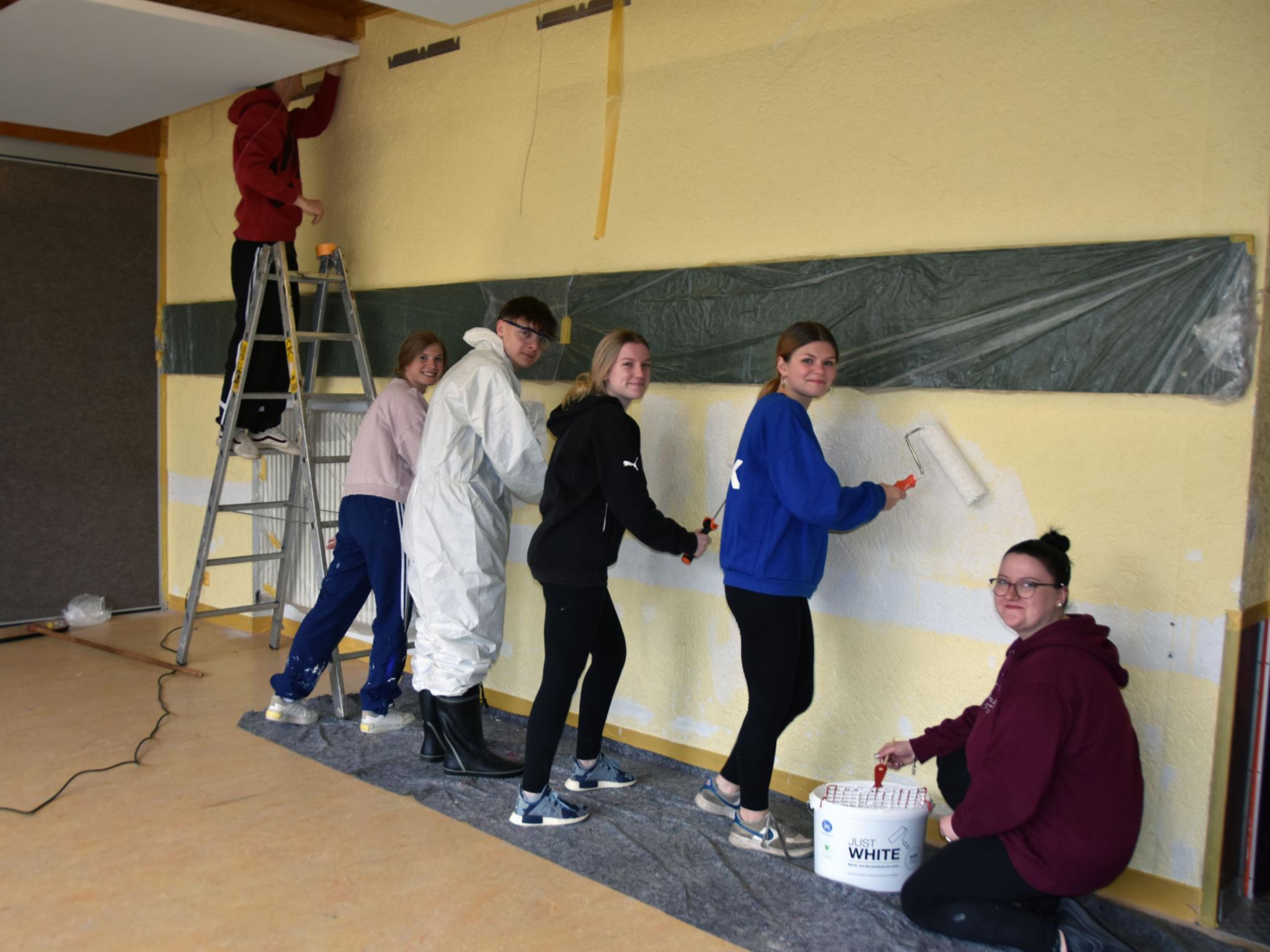 Marcel, Laura, Joshua, Jule, Charlotte und Samira (vlnr) streichen das Pfarrheim, das von der Kita als Turnhalle genutzt wird.