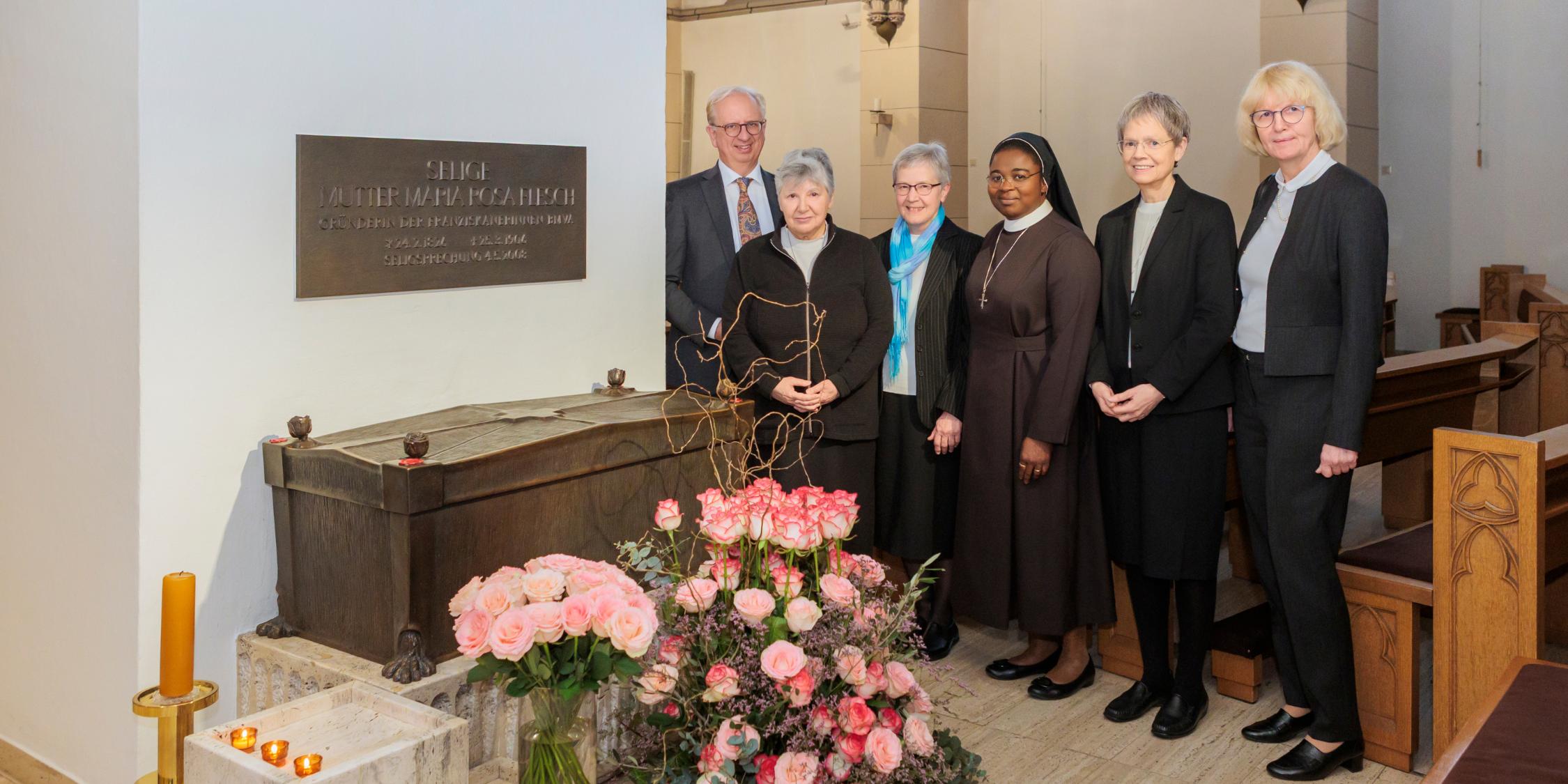 Die Ordensleitung mit Generaloberin Sr. M. Michaele Rohde (2. von rechts), Sr. M. Diane Tobossi (3. von rechts), Sr. Gerlinde-Maria Gard (3. von links) und Sr. Jutta Maria Musker (2. von links) zusammen mit Dr. Heinz-Jürgen Scheid, dem Vorstandsvorsitzenden der Marienhaus Stiftung, und Birgitta Lorke, der Vorsitzenden des Aufsichtsrats der Marienhaus GmbH, am Sarkophag der Seligen Mutter Rosa