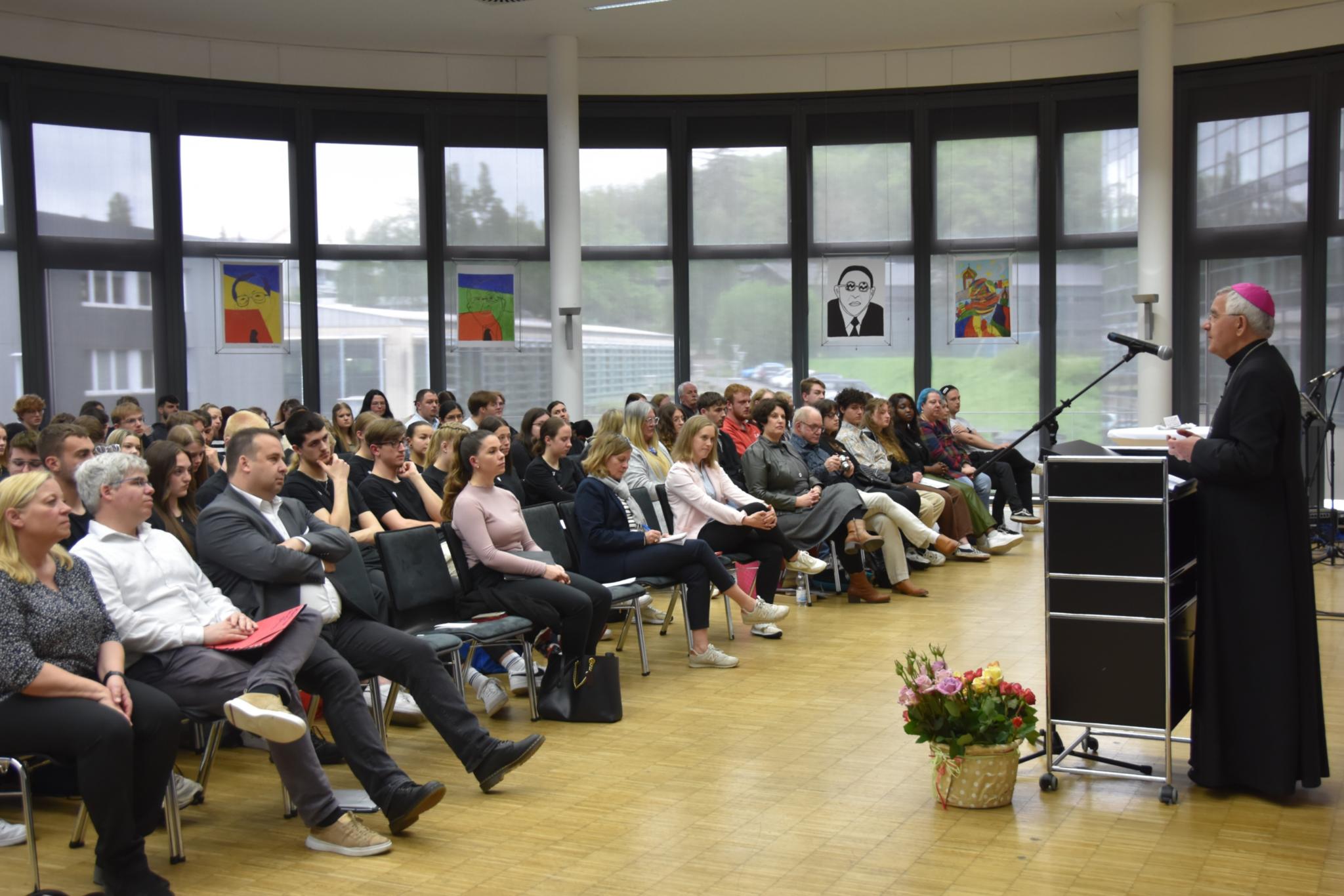 Weihbischof Gebert am Rednerpult vor Publikum