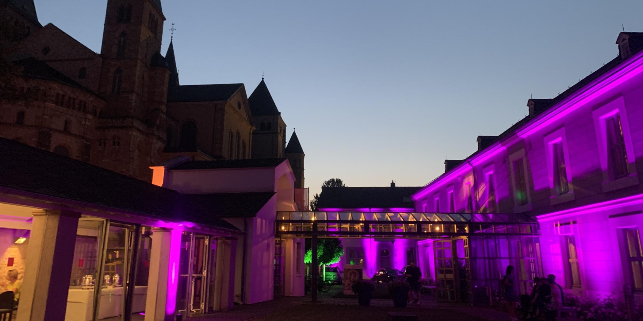Das Museum am Dom Trier ist für die Museumsnacht von außen in Farben wie Pink und Gelb beleuchtet.