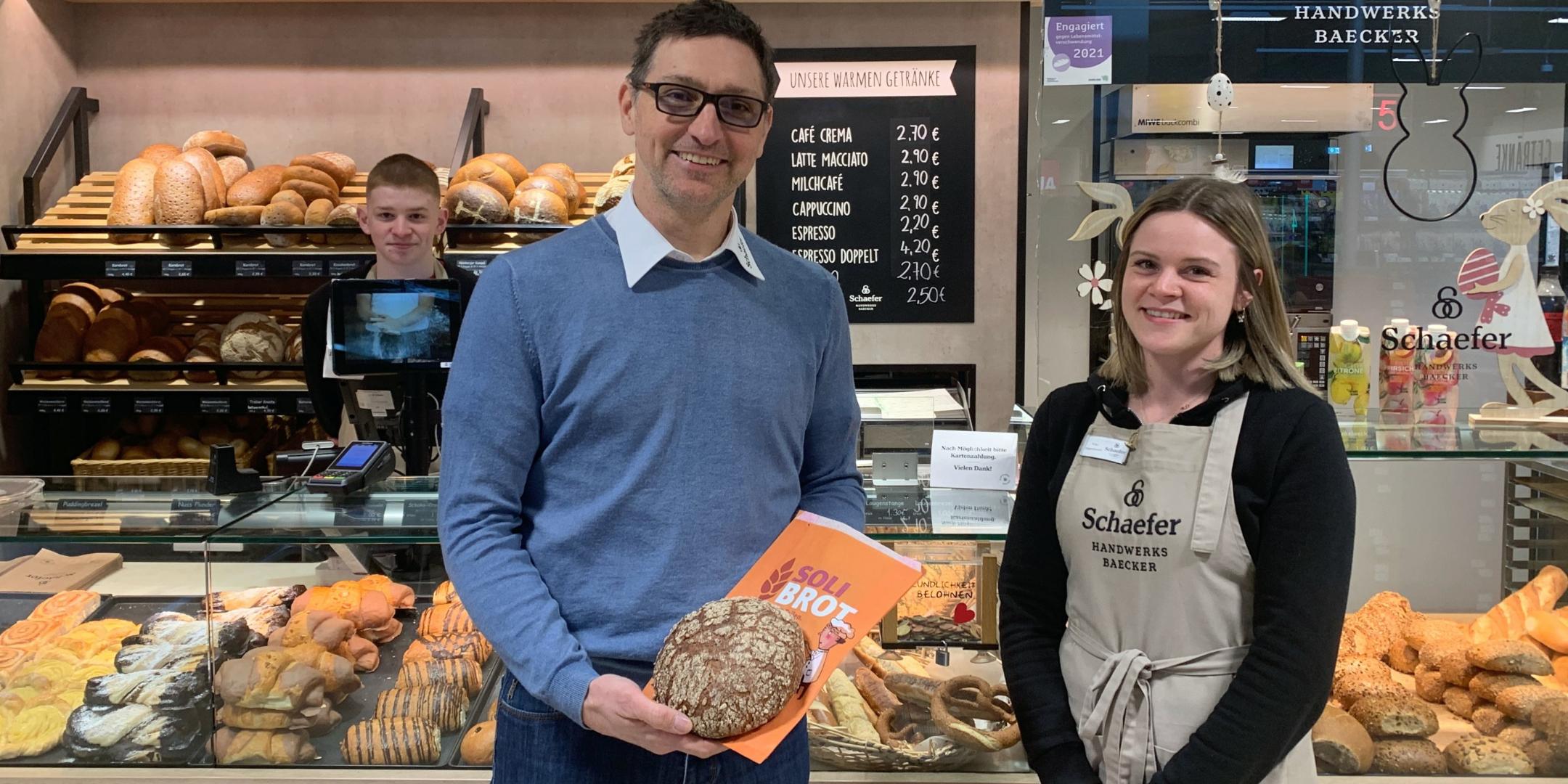 Bäckermeister Sebastian Schaefer präsentiert das Soli-Brot mit seinen Auszubildenden Melanie Wagenknecht und Nico Schiestel.