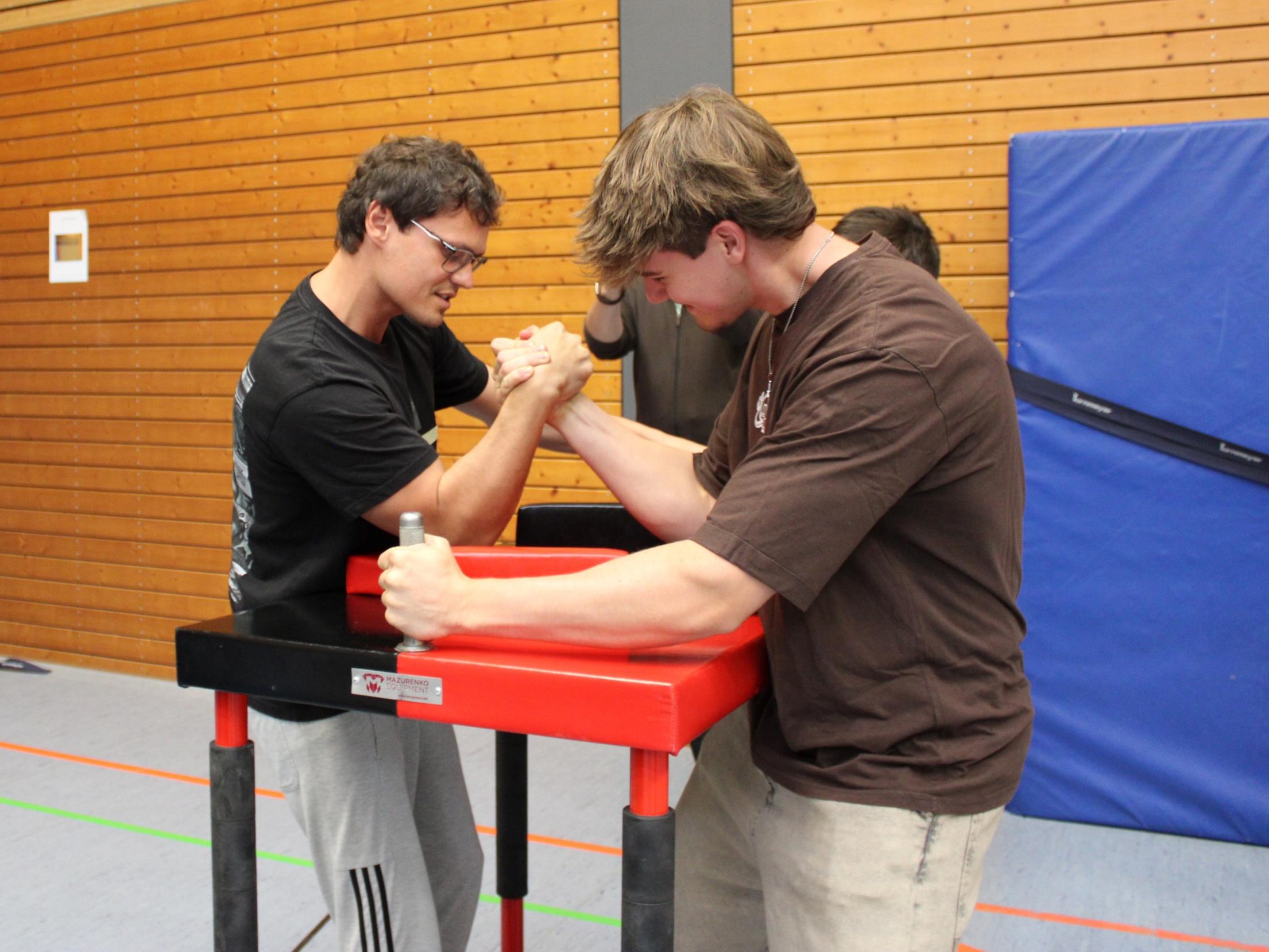 Trainer Evgenij führt Elias ins Armdrücken ein.