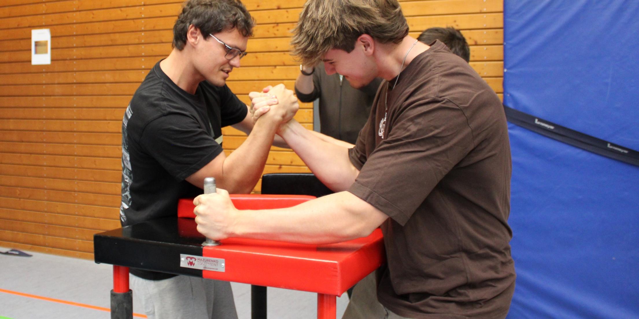 Trainer Evgenij führt Elias ins Armdrücken ein.