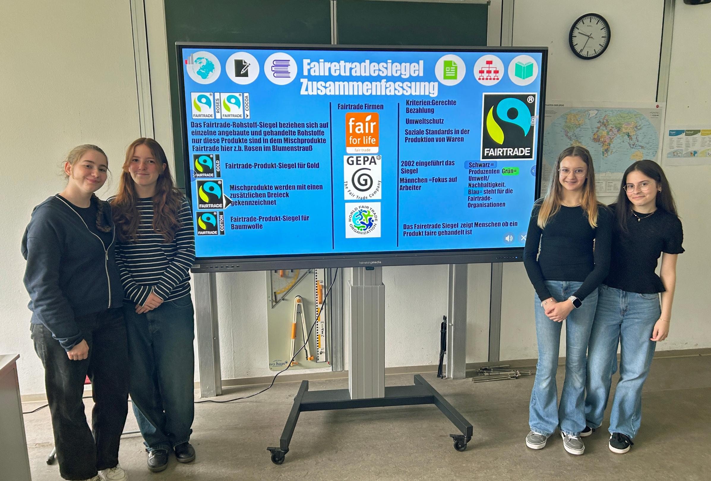 Angelina, Maja, Emily und Ilenia erklären den jüngeren Schülern, was die verschiedenen Fairtrade-Logos bedeuten.