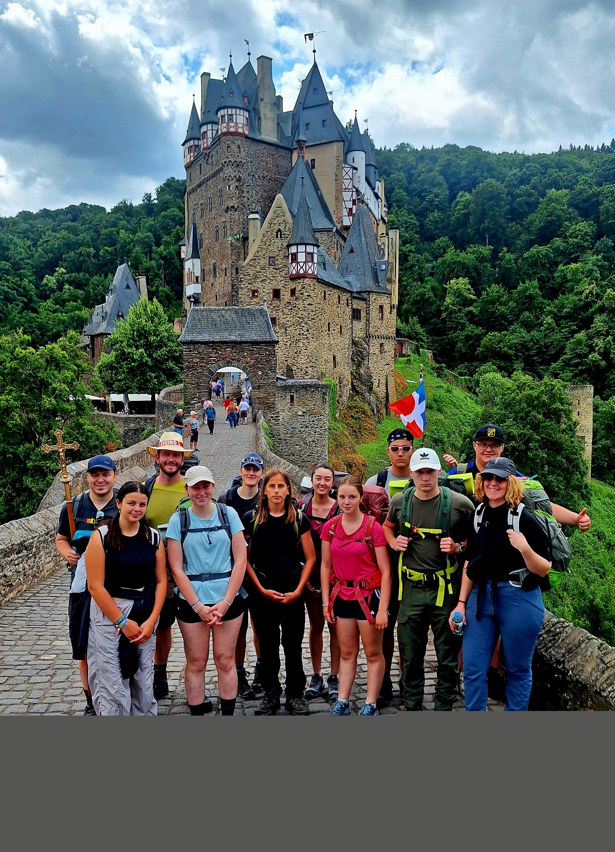 Die jungen Menschen stehen vor einer Burg