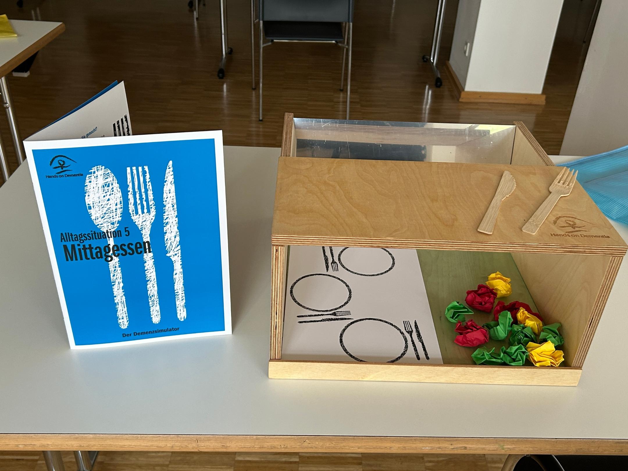 Eine Kiste mit Spiegel ist eine Station des Demenzparcours, an der die Hürden eines Essens für Betroffene deutlich wird.