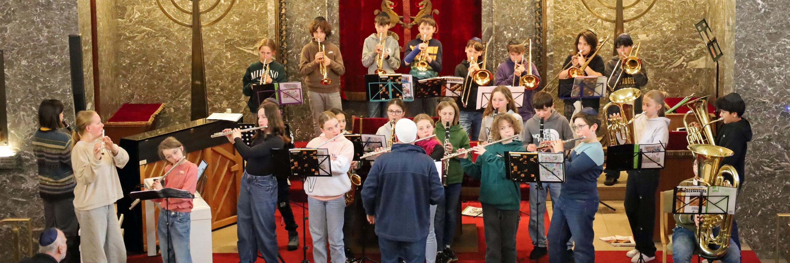 Eine Gruppe mit Blasinstrumenten probt für einen Auftritt