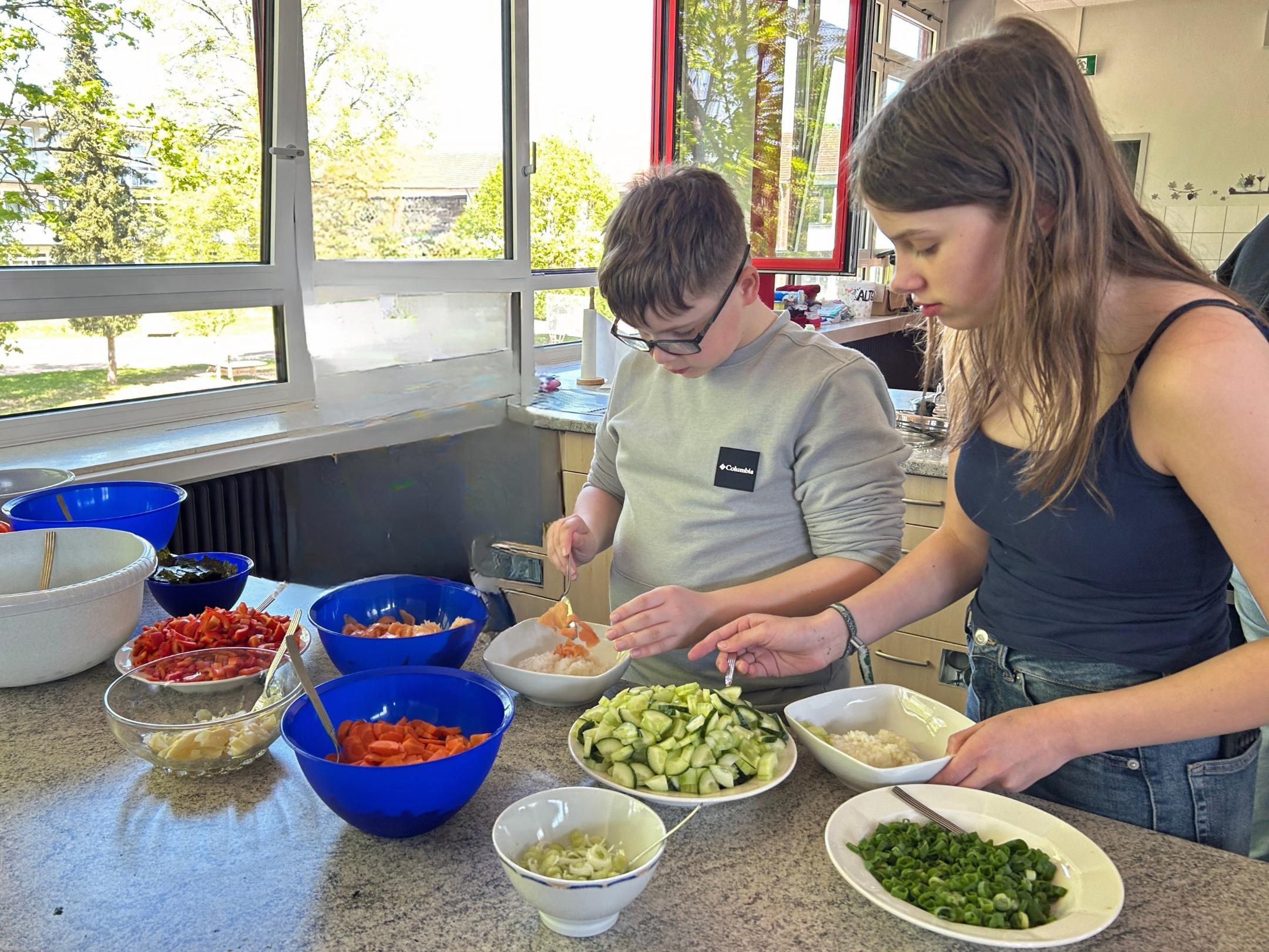 Kay und Vivien stellen ihre Sushi-Bowls zusammen.