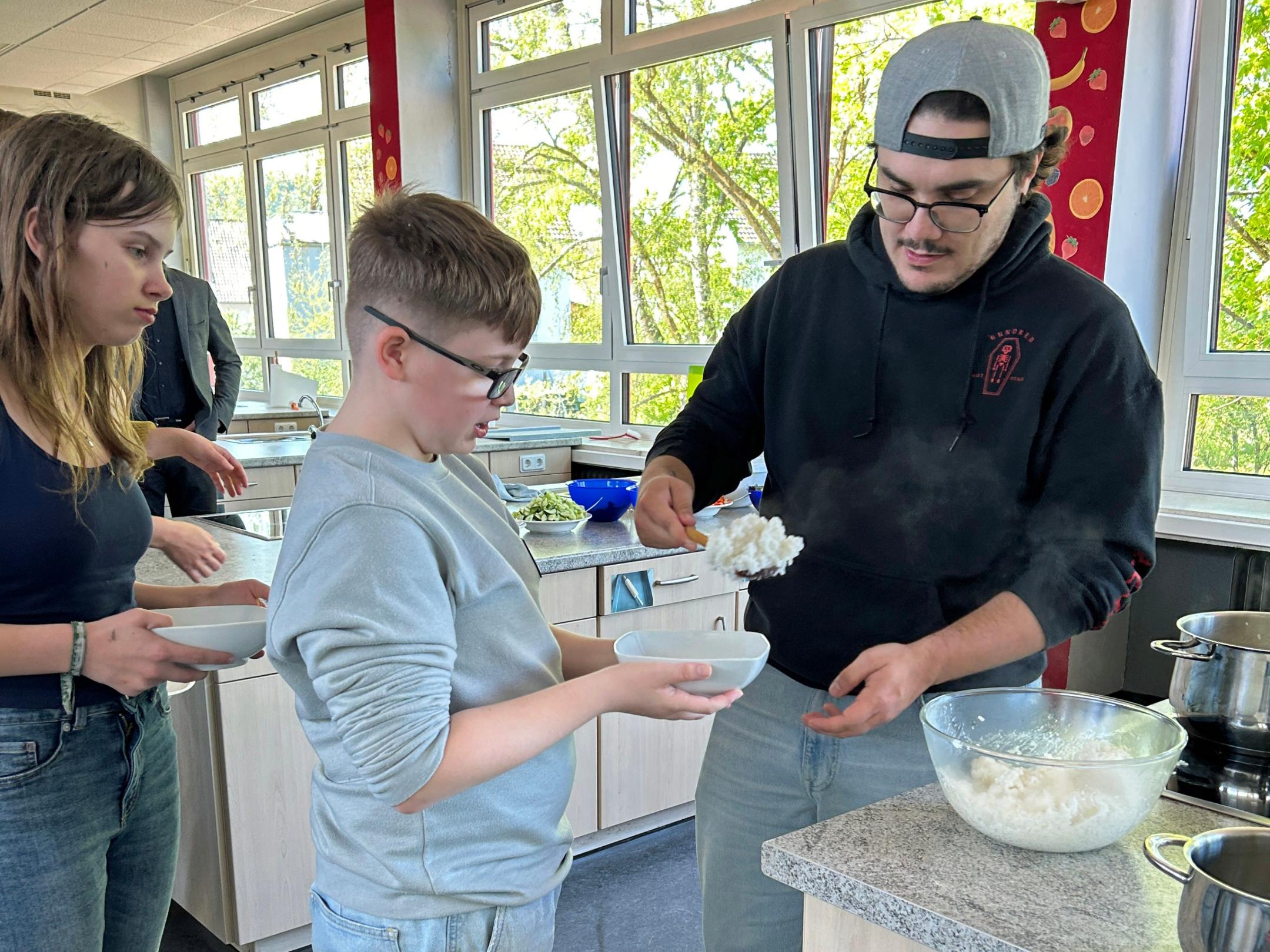 Schulsozialarbeiter Sandro Bennici teilt den Sushi-Reis für die Bowls aus.