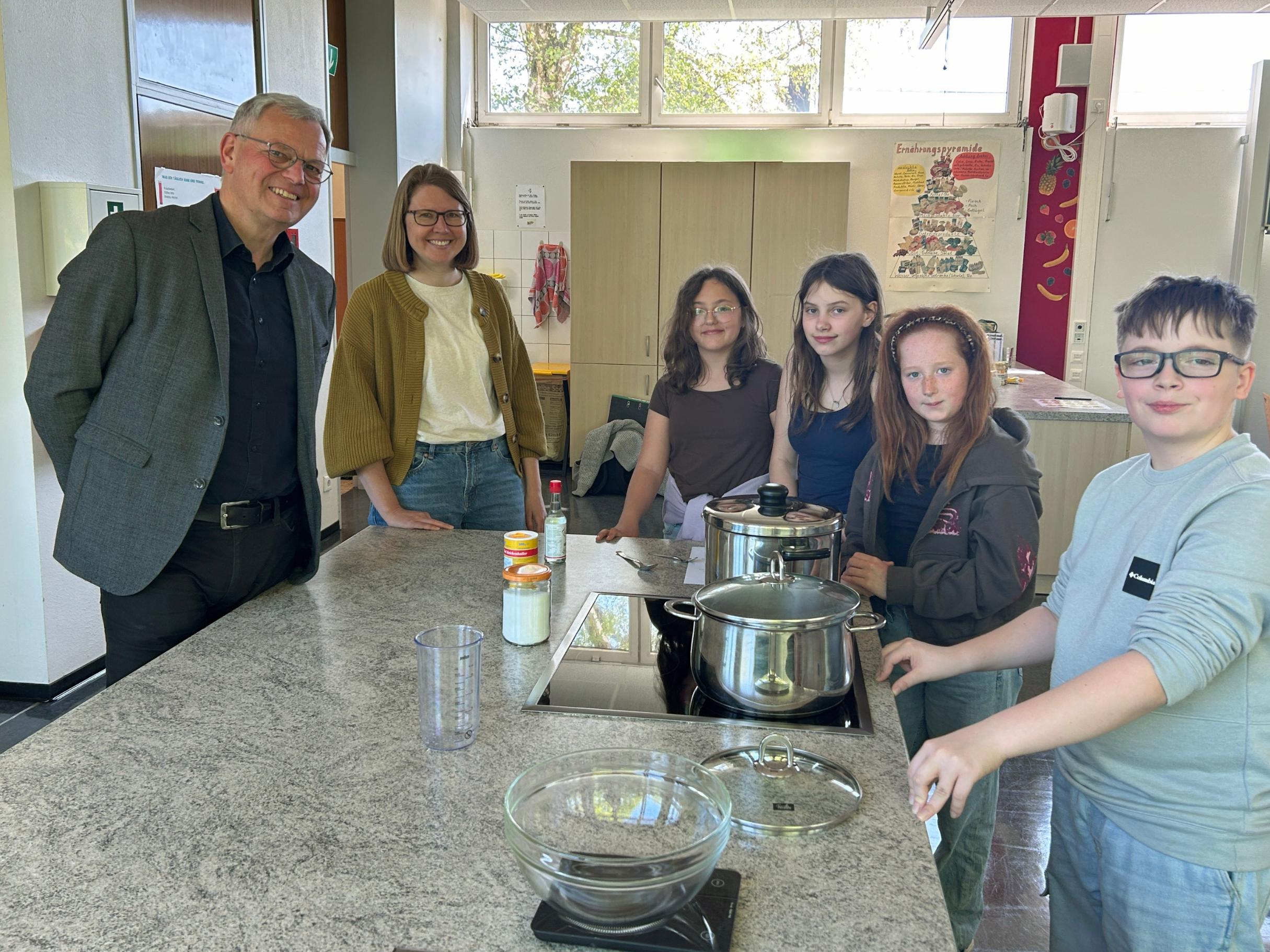 Bischofsvikar Ulrich von Plettenberg, Pastoralreferentin Carina Rui, Vivienne, Vivien, Mailin und Kay kochen den Reis für die Sushi-Bowls.