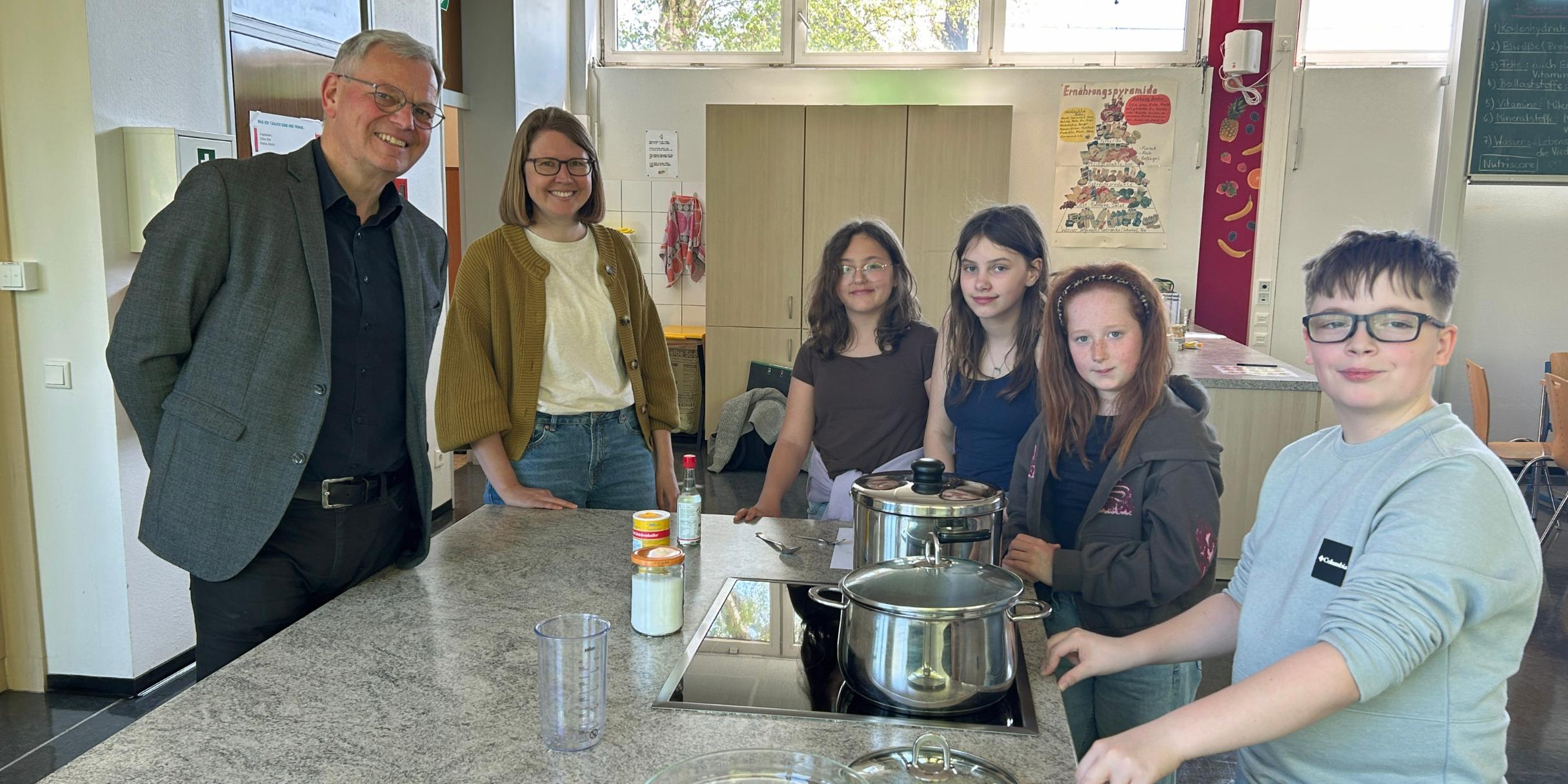 Bischofsvikar Ulrich von Plettenberg, Pastoralreferentin Carina Rui, Vivienne, Vivien, Mailin und Kay kochen den Reis für die Sushi-Bowls.