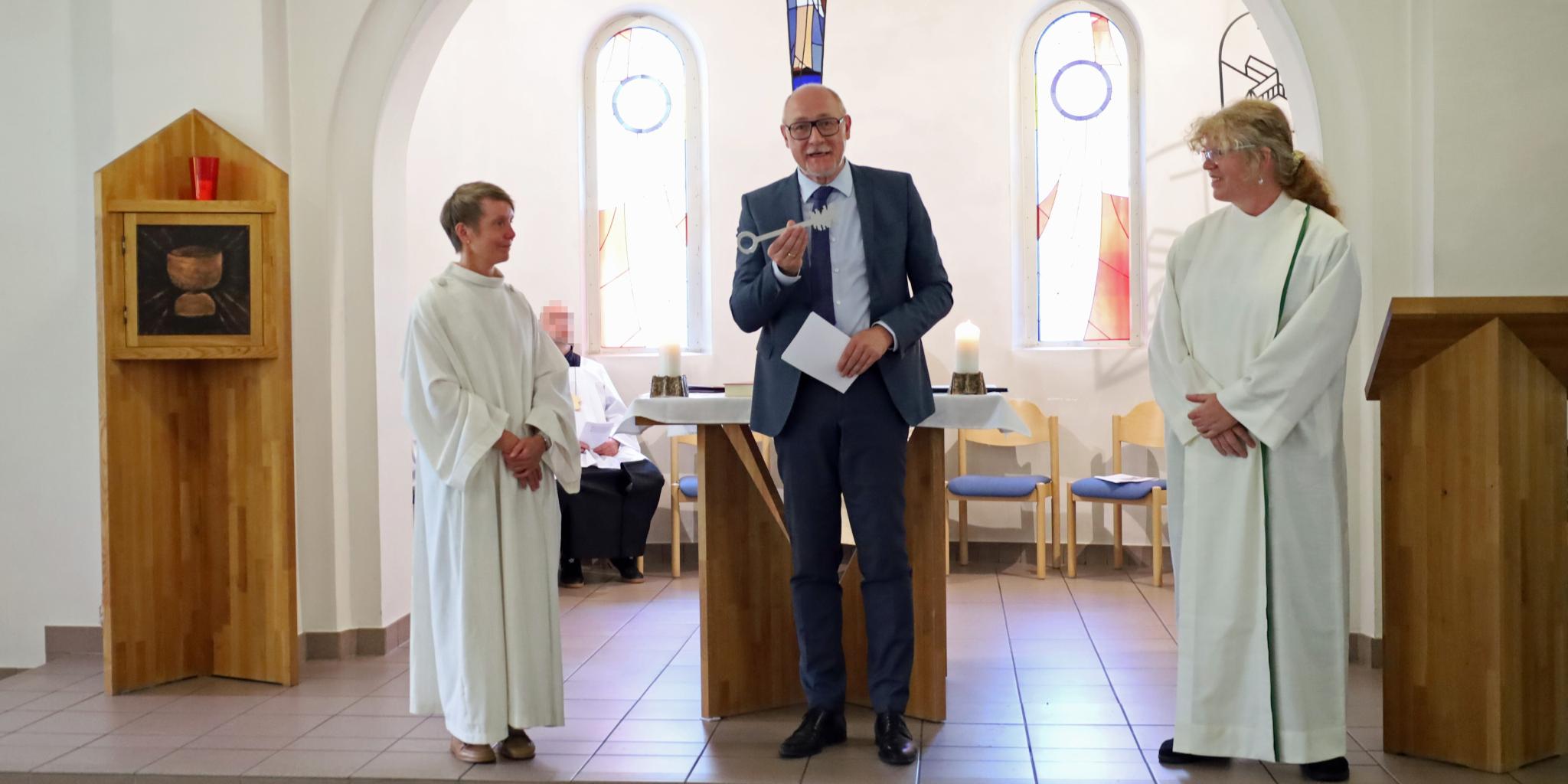 Der Leiter der Abteilung Seelsorge und Lebenswelten im Bischöflichen Generalvikariat Ulrich Stinner (Mitte) übergibt symbolisch den Schlüssel von Carmen Folz (links) an Marion Bexten (rechts).