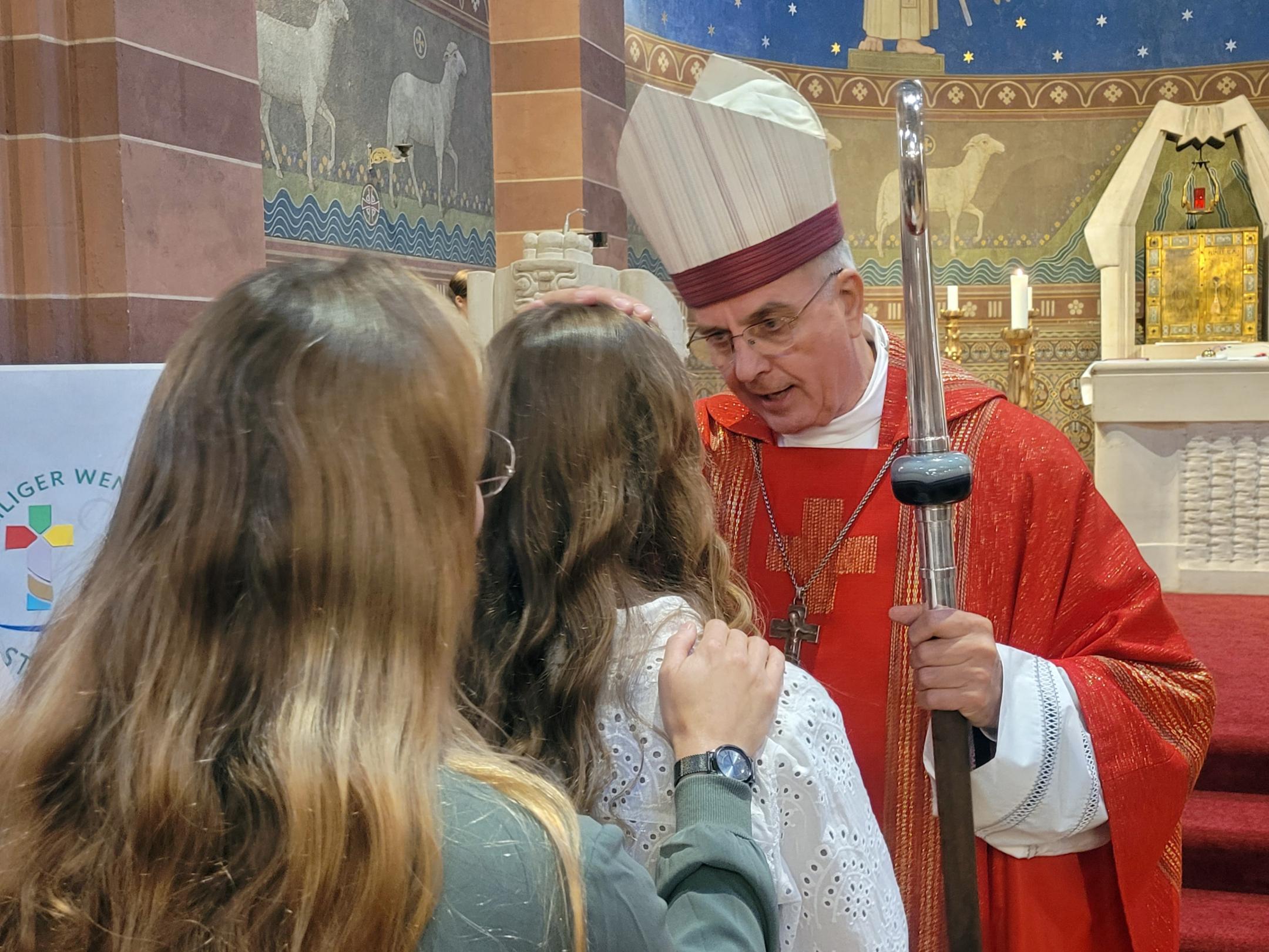 Weihbischof Jörg Peters firmt eine Jugendliche in St. Remigius in Bliesen.