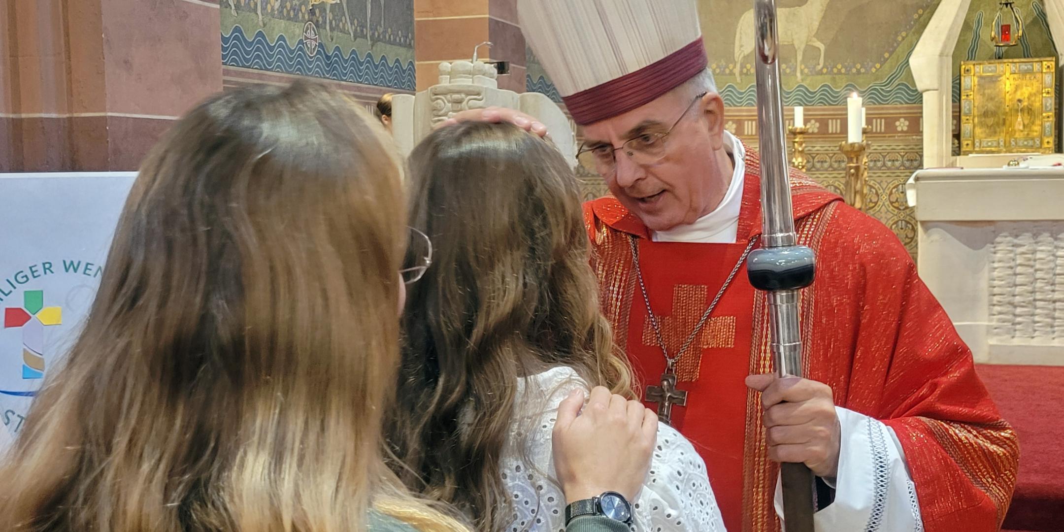 Weihbischof Jörg Peters firmt eine Jugendliche in St. Remigius in Bliesen.