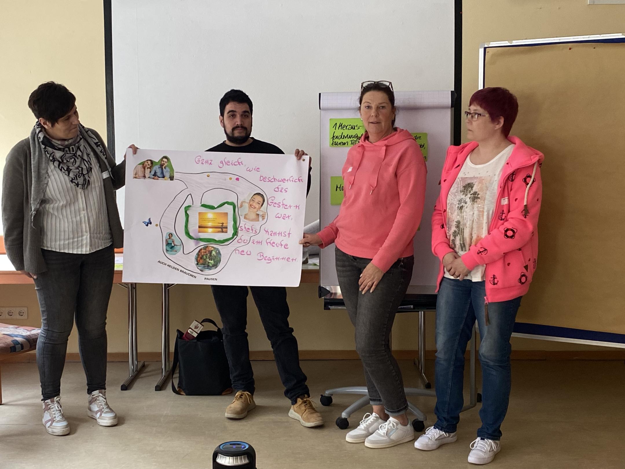 4 junge Menschen mit einem Plakat
