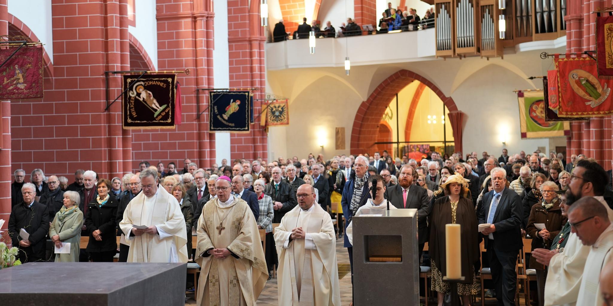 Während der Allerheiligenlitanei zur Weihe des neuen Altars stehen Pfr. Hans-Günther Ullrich, Bischof Ackermann, Pfr. Markus Nicolay vor der Altarinsel, die Gottesdienstgemeinde mit Oberbürgermeister Wolfram Leibe, Kulturdezernent Markus Nöhl und Baudezernent Andreas Ludwig stehen hinter ihnen.