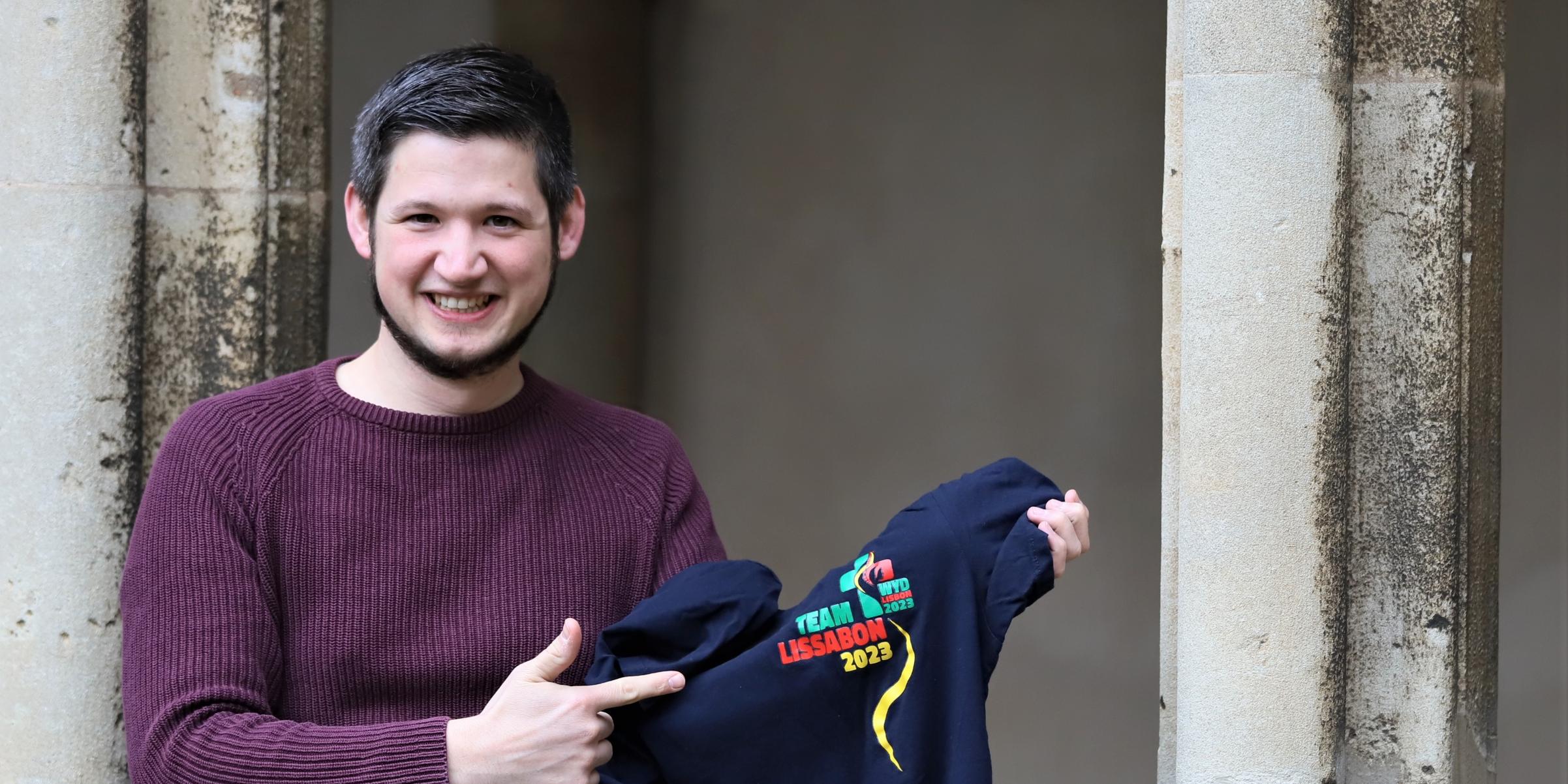 Benedikt Welter von der Abteilung Jugend im Bistum Trier zeigt ein T-Shirt vom Weltjugendtag 2023 in Lissabon