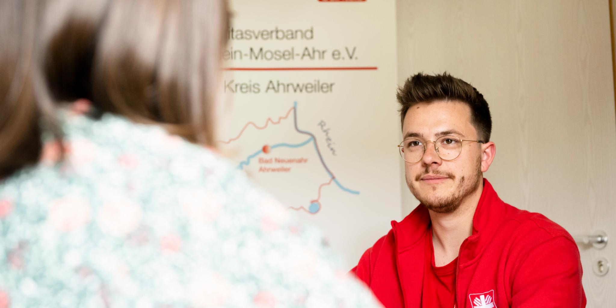 Ein Mitarbeiter der Caritas Ahrweiler berät und hilft Betroffenen im Gespräch