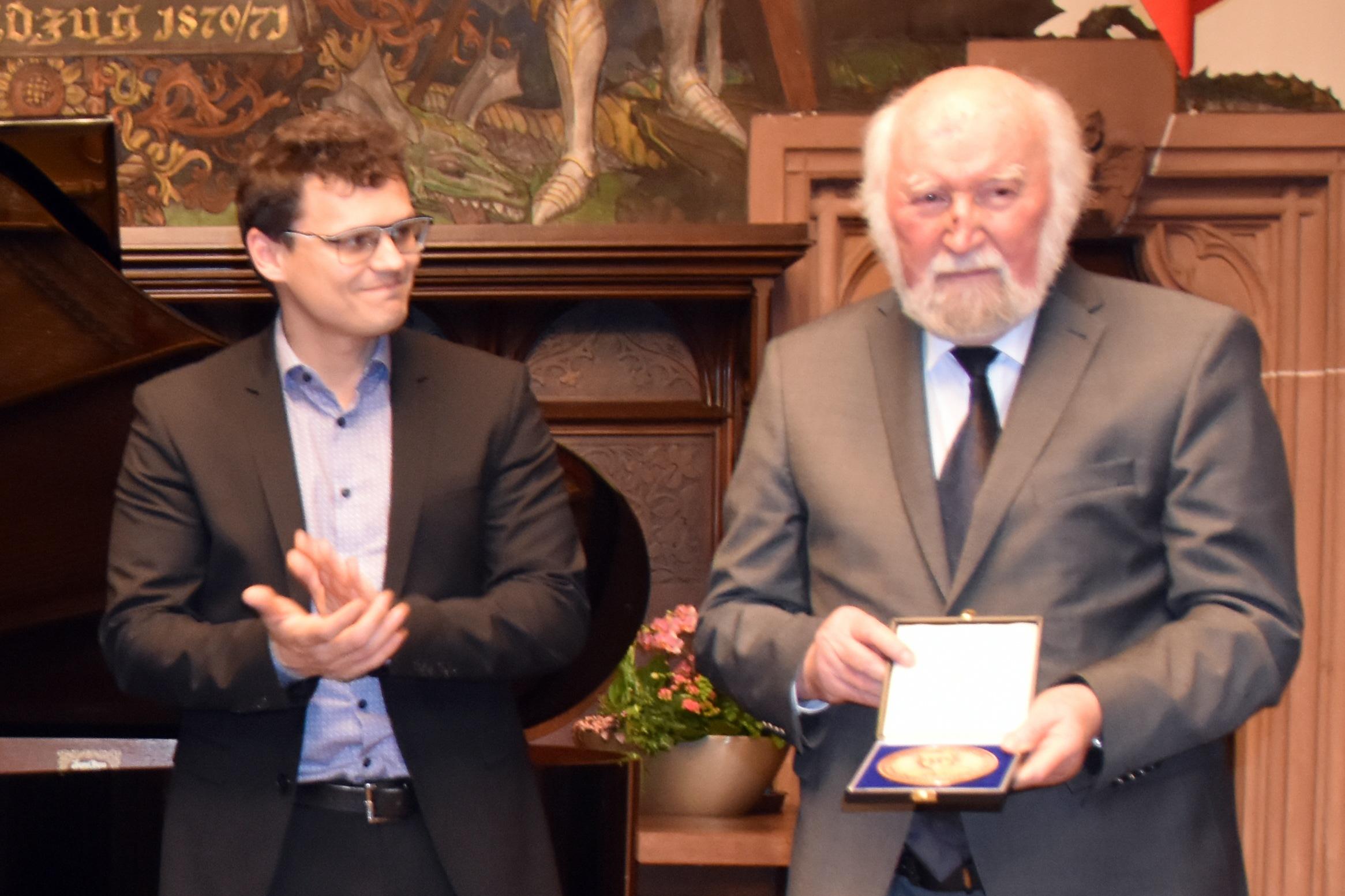 Der Geschäftsführer der Synogogengemeinde Saar Evgenij Mrinski überreicht Professor Herbert Jochum die Friedrich-Schlomo-Rabbiner-Rülf-Medaille.