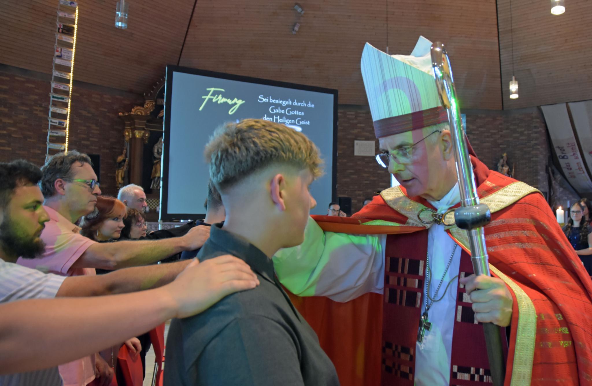 Weihbischof Jörg Peters spendet Jugendlichen in der Jugendkirche MIA in Weiskirchen-Rappweiler das Sakrament der Firmung.