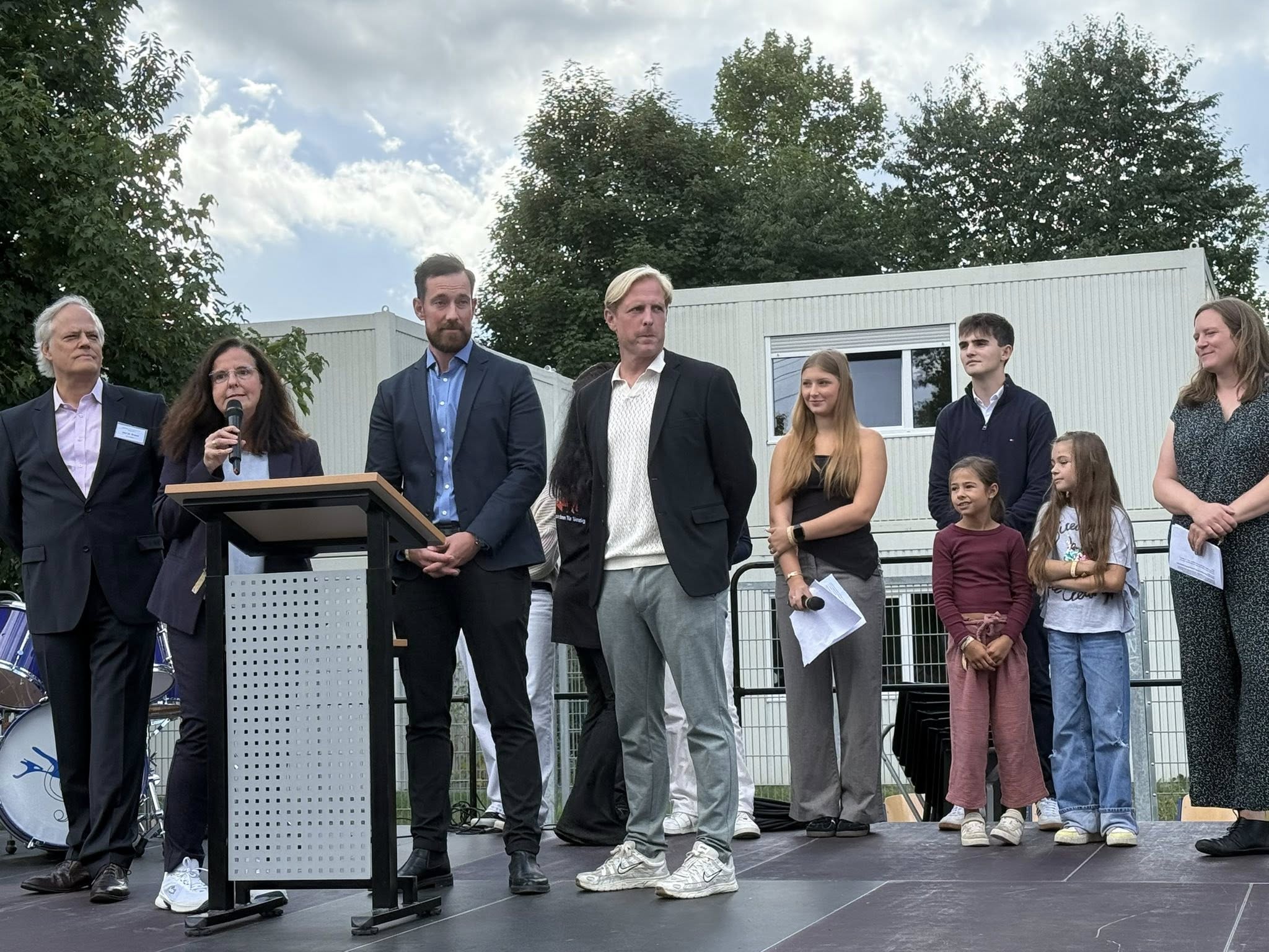 Von links: Dr. Jens Braner (Rheingymnasium), Uta Erlekampf (Barbarossaschule), Florian Beck (Regenbogenschule), Andreas Schmitt (Janusz-Korzcak Schule), im Hintergrund Schülersprecher*innen des Rheingymnasiums, Schüler*innen der Regenbogenschule und rechts Dr. Eva Polch (Schulkoordinatorin)