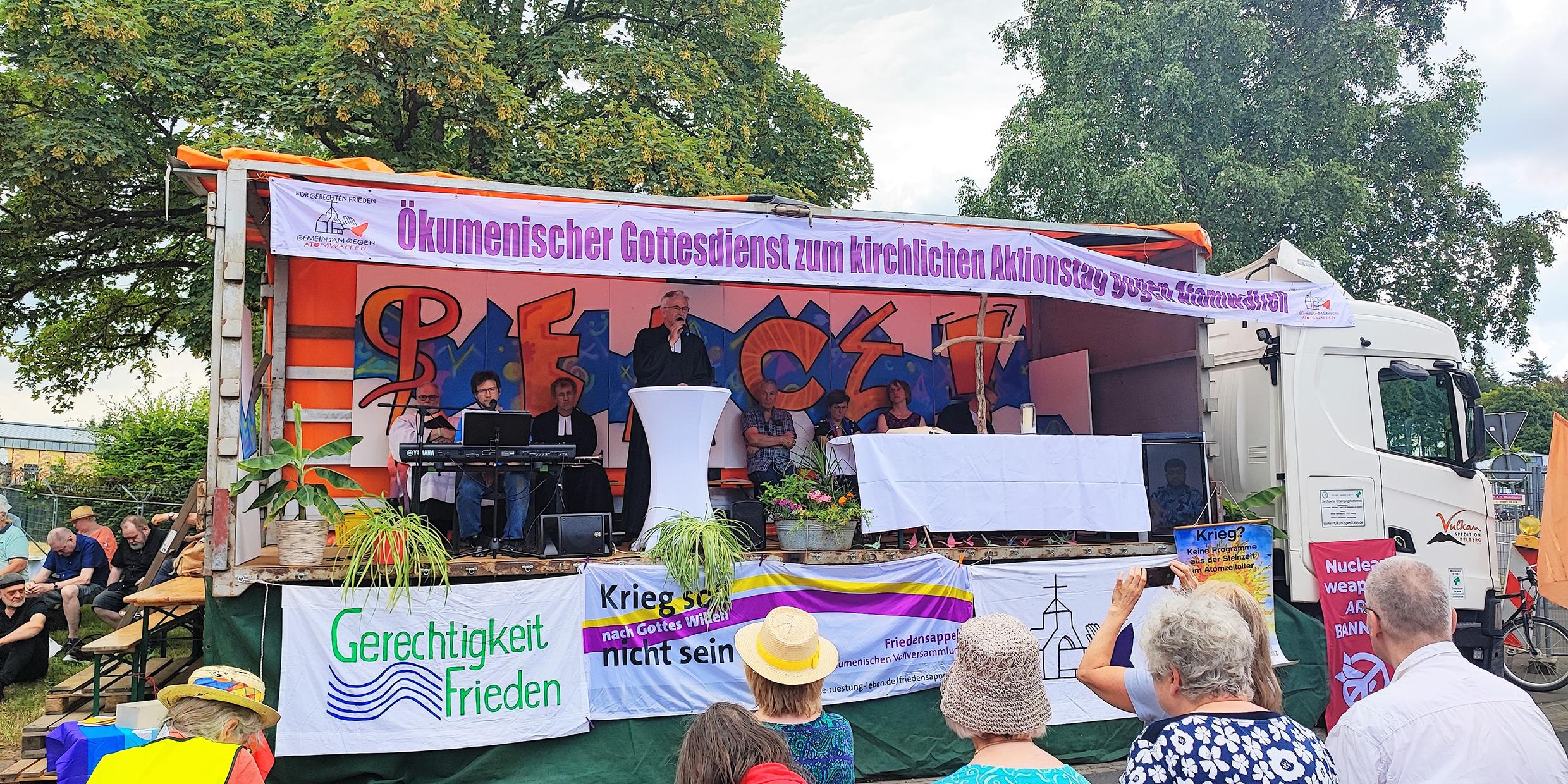 Der frühere Landesbischof Cornelius-Bundschuh (Mitte) predigt im ökumenischen Gottesdienst vor dem Fliegerhorst in Büchel.