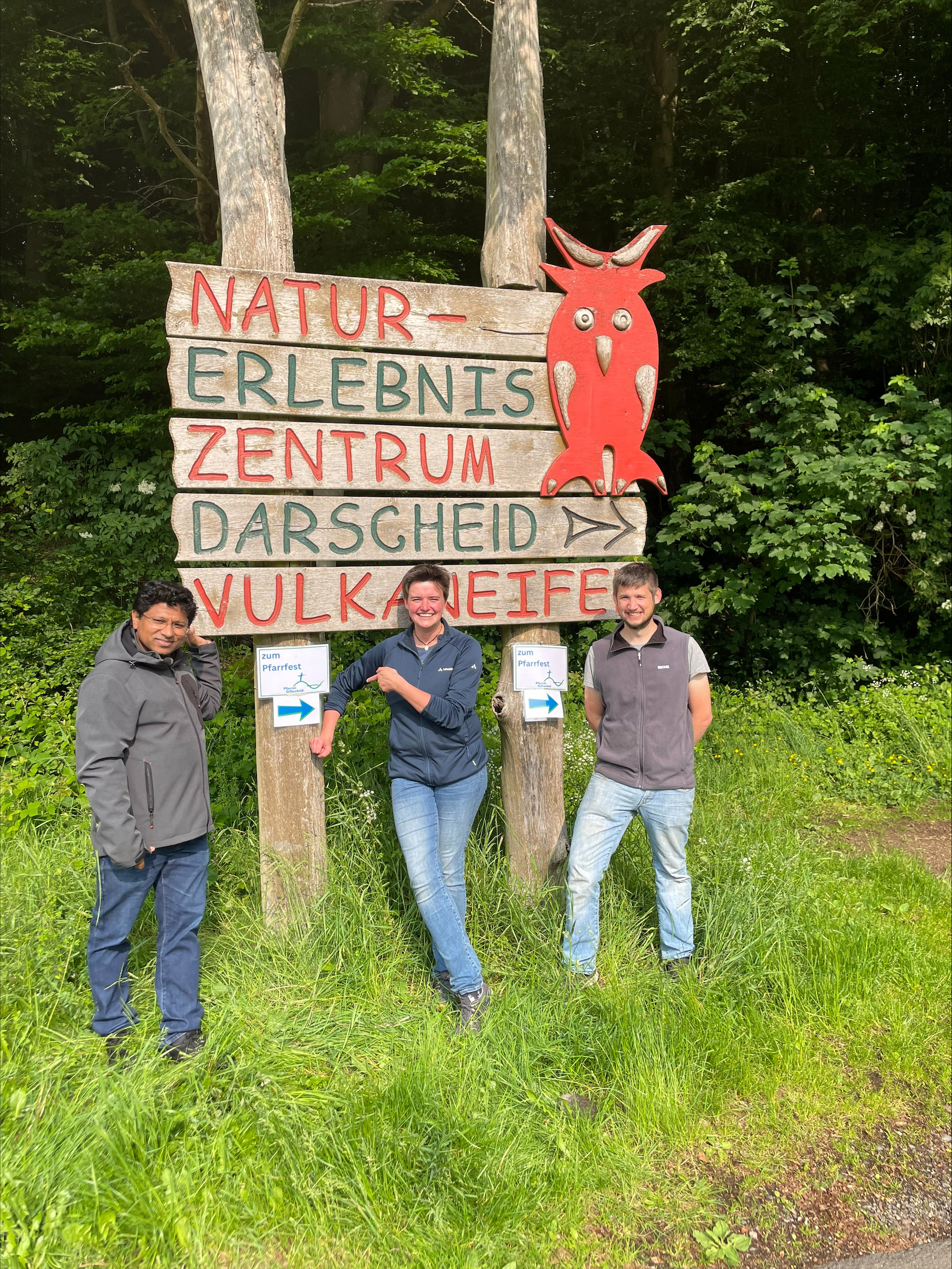 Drei Menschen posieren vor einem Schild des Naturerlebniszentrum Dahrscheid