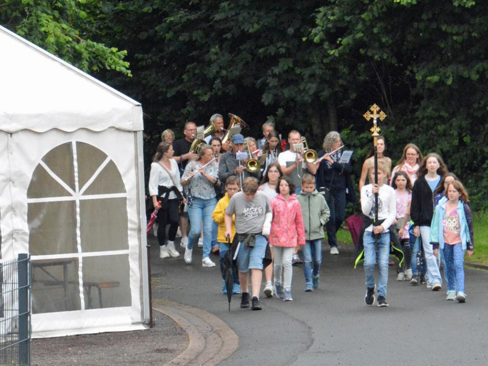 Eine Gruppe von Kindern wandert, vornweg trägt ein Kind ein Kreuz