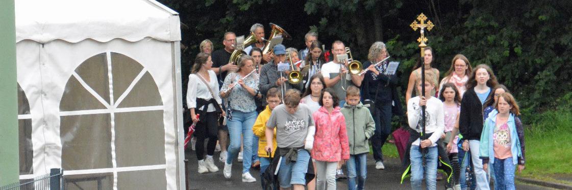 Eine Gruppe von Kindern wandert, vornweg trägt ein Kind ein Kreuz
