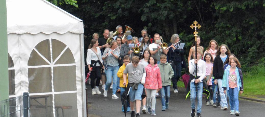 Eine Gruppe von Kindern wandert, vornweg trägt ein Kind ein Kreuz