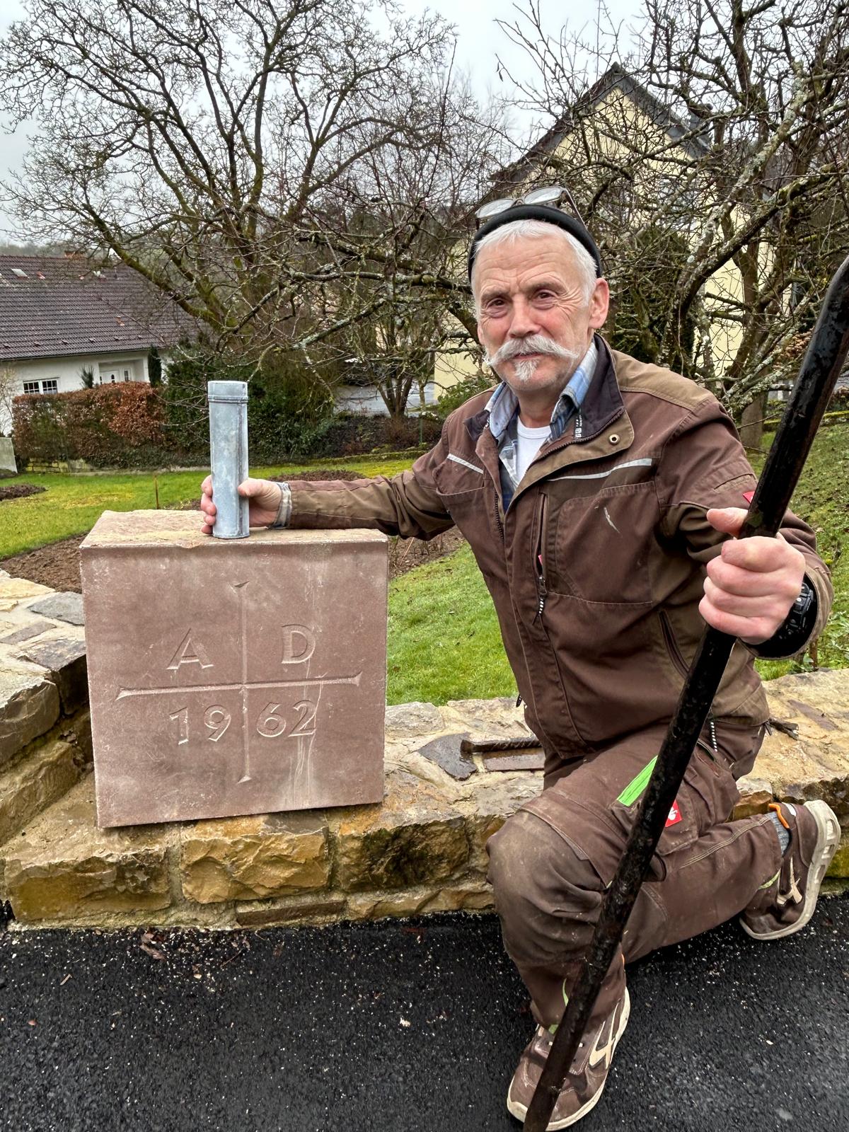 Das Bild zeigt Albert Weber und den Gründungsstein zusammen mit der Zeitkapsel