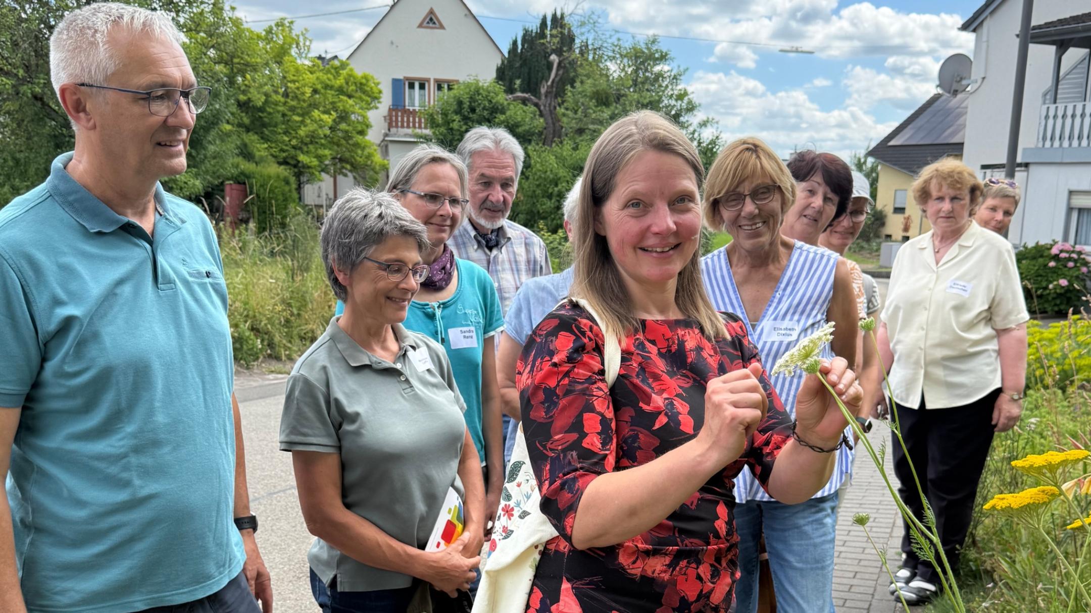 Referentin Annette Fehrholz zeigt den Teilnehmenden Pflanzflächen in Föhren vor.