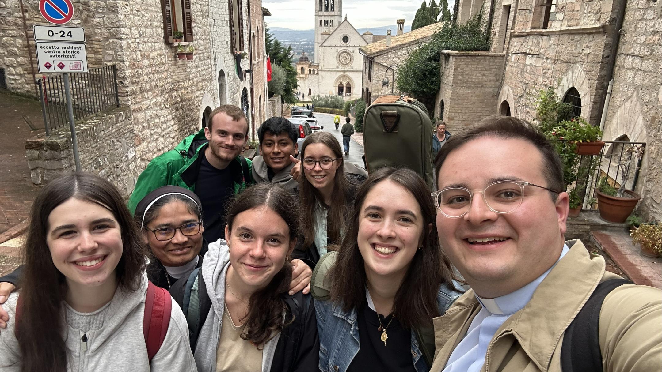 Eine Gruppe junger Menschen machen ein Selfie in einer historischen Straße.