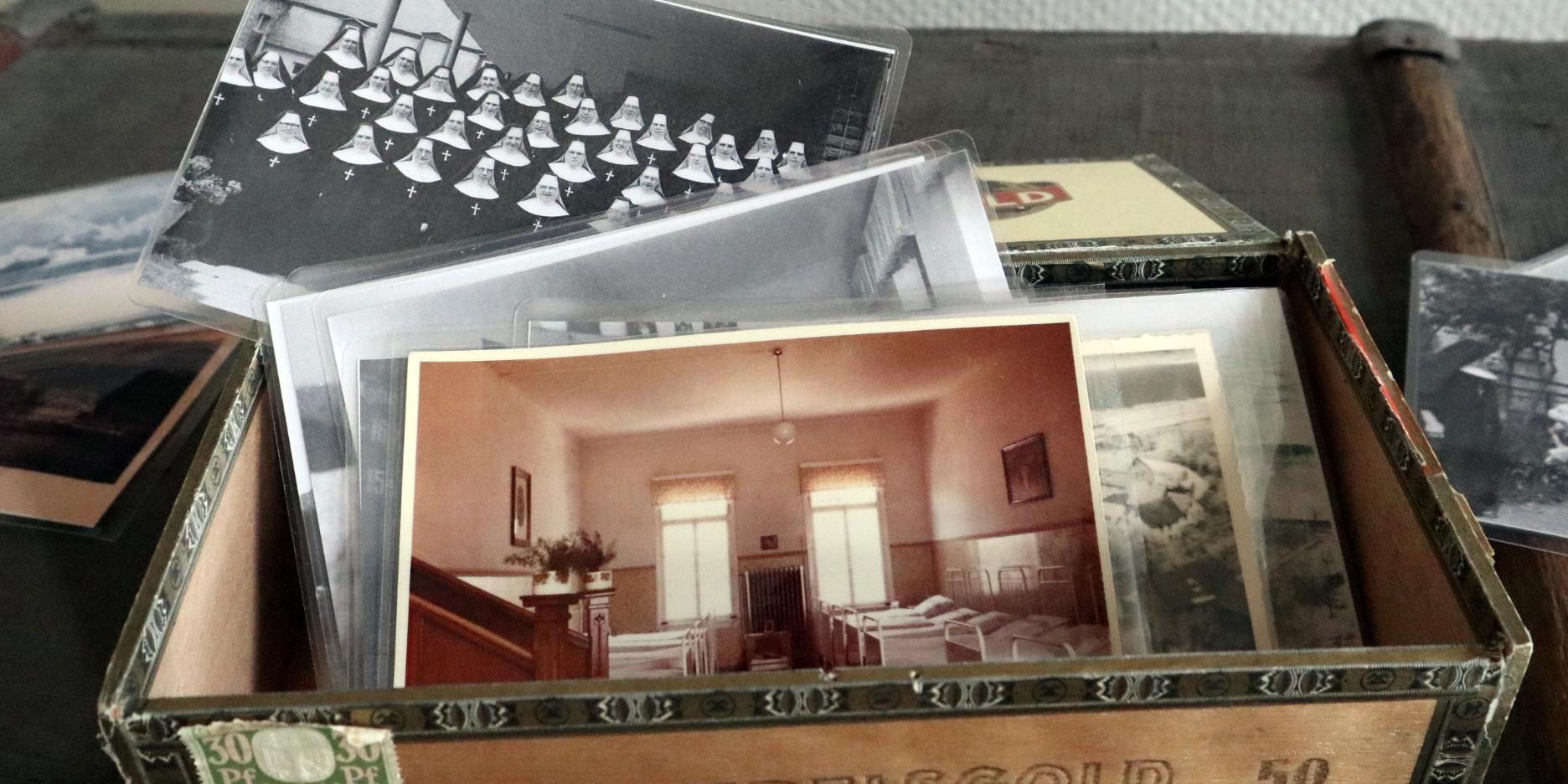 Eine Box mit alten schwarz-weiß Fotos.