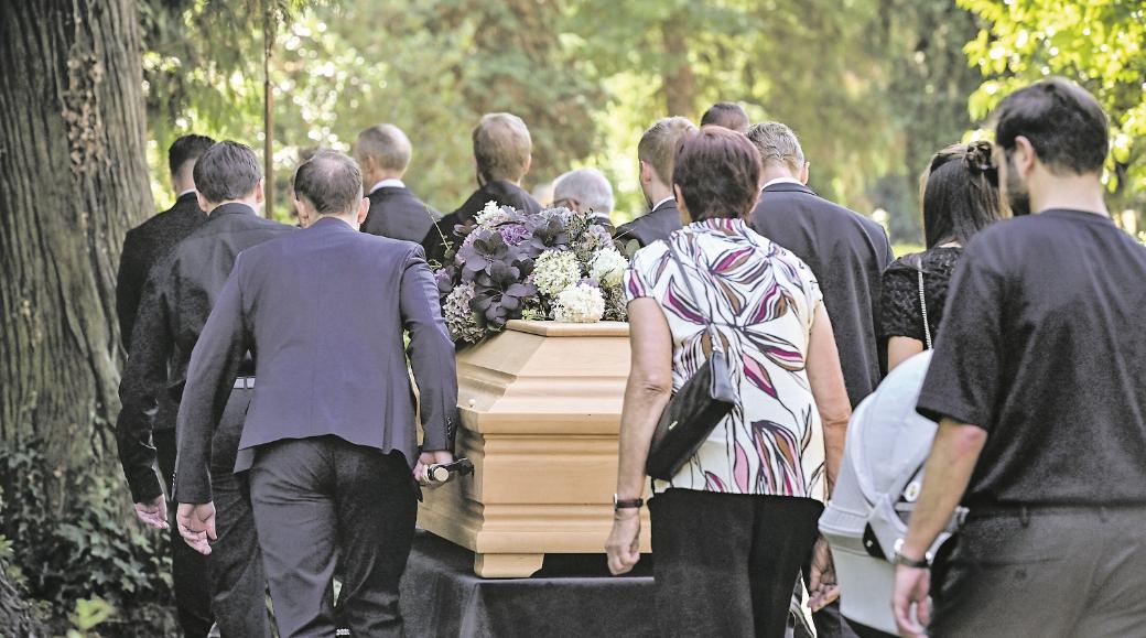 Sargträger und Trauernde auf dem Weg zum Grab.