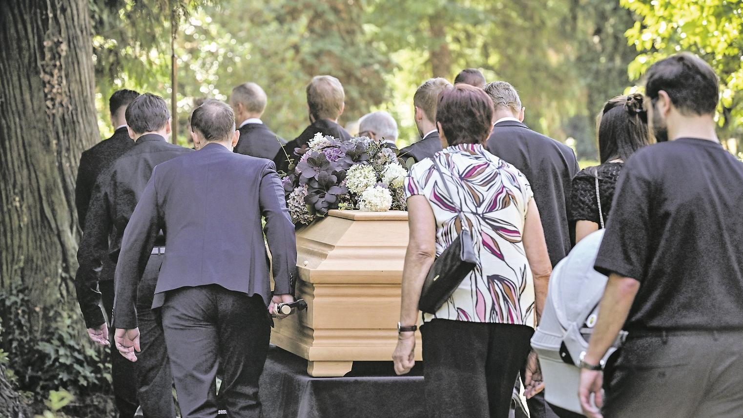 Sargträger und Trauernde auf dem Weg zum Grab.