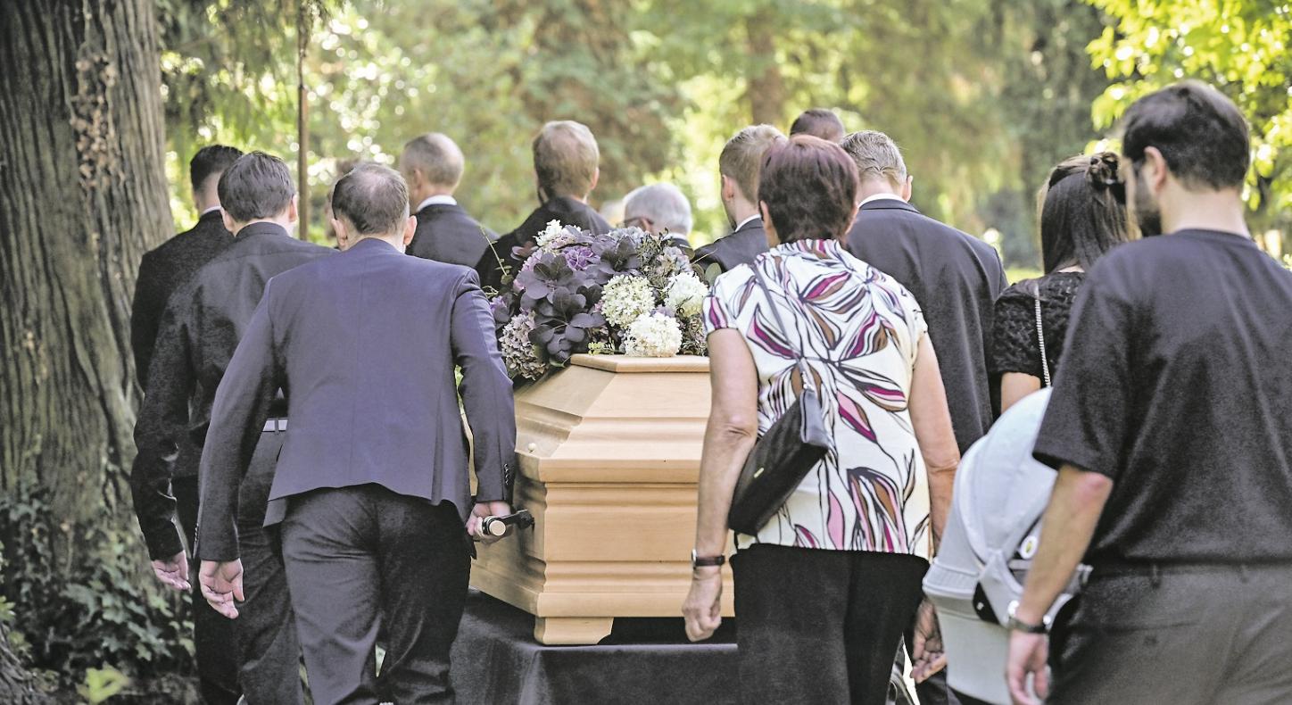 Sargträger und Trauernde auf dem Weg zum Grab.