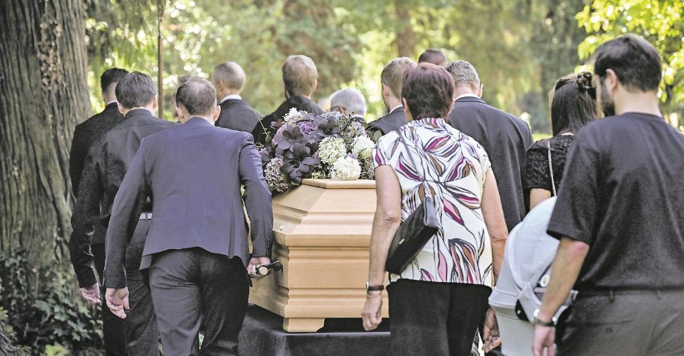 Sargträger und Trauernde auf dem Weg zum Grab.